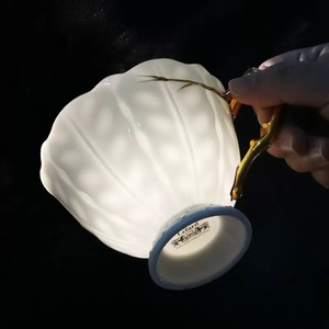 European High Quality Embossed Leaf Pattern Bone <b>China</b> Coffee <b>Cup</b> and Saucer Set featuring gold rim and handle - Product Image 1