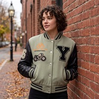 Blouson universitaire femme court en laine vert sauge et noir avec manches en cuir, patch moto en chenille personnalisé