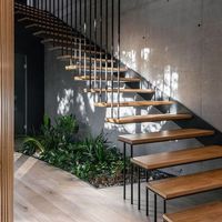 Escalier flottant en acier avec garde-corps en verre et bandes de roulement modernes en bois massif pour appartement intérieur