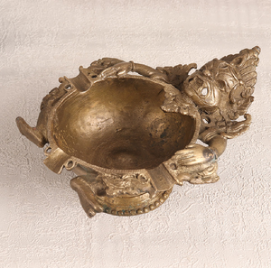 Exuding traditional Indian artistry, this striking brass <b>ashtray</b> features an intricately carved mythical face - Product Image 1