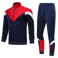 Survêtement sportif pour homme, bleu, noir et blanc, avec blocs de couleur, col roulé zippé, poches latérales, idéal pour l'automne
