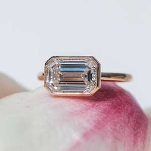 East West Emerald Cut CZ Anillo solitario en oro rosa | Banda de compromiso con bisel de 6x8mm - Product Image 1