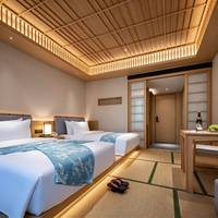 Ensemble de meubles en bois massif pour chambre double d'hôtel japonais : tête de lit, lit, coffre de rangement, zone tatami, table d'étude, porte coulissante, mur de fond