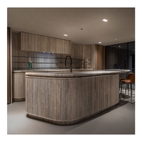 Meuble de cuisine moderne avec panneau cannelé incurvé, comptoir en marbre et rangement en bois laqué pour villa