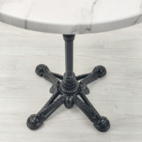 Table ronde de salle à manger de style français avec plateau en MDF à motif marbré classique de 70 cm de diamètre et base en fonte, idéale pour les restaurants en plein air, les bistrots et les cafés.