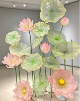 Composition florale géante en organza transparent, lotus rose en maille et feuilles vertes sur support pour vitrine d'exposition, style oriental
