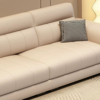 Canapé 3 places en cuir technique avec surpiqûres en V, accoudoirs incurvés et poches latérales de rangement, idéal pour salon moderne