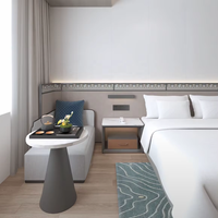 Ensemble de meubles pour chambre d'hôtel avec tête de lit, tables de chevet, meuble TV mural, fauteuil lounge et table d'appoint ronde