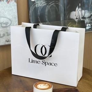 Emballage de <span class=keywords><strong>sac</strong></span> en papier kraft de luxe recyclable avec logo imprimé personnalisé <span class=keywords><strong>sac</strong></span> en papier avec poignée de magasinage de cadeau de vêtement imprimé avec logo - Product Image 1