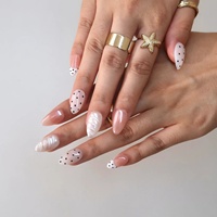 Ongles en acrylique à presser, blanc laiteux, à pois noirs, gaufrés 3D, texture nacrée rose nude, forme amande délicate