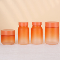 Bouteille en verre de qualité alimentaire de couleur orange givrée personnalisée de forme cylindrique pour produit de soin masculin avec bouchon déshydratant en or brillant
