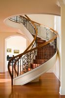 Escalier intérieur moderne en acier inoxydable courbé avec garde-corps en fer forgé, durable et écologique, pour hall d'entrée d'hôtel, villa, avec lustre mobile
