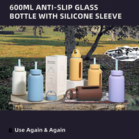 Bouteille d'eau portable en verre avec manchon en silicone antidérapant de 600 ml, double couvercle, design moderne, réutilisable, nouveauté pour l'extérieur, vente en gros