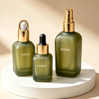Flacon compte-gouttes en verre vert olive dépoli, flacon de sérum de luxe à forme carrée douce, emballage écologique pour soins botaniques du visage et huiles.