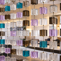 Système de suspension pour briques de verre transparentes et colorées avec kit de câbles en acier pour cloisons de bureau modernes, écrans de séparation et présentoirs muraux.