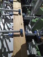 Machine polyvalente d'enveloppement de profilés à colle chaude pour produits en bois