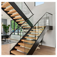 Escalier sur mesure à double poutre, structure en acier en U, marches en hêtre massif, panneaux en verre, finition blanche thermolaquée