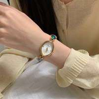 Montre à maillons de perles de style bijoux avec cadran ovale doré pour présentation en boutique