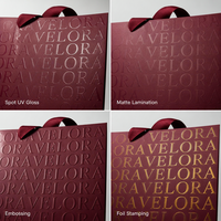Sac en papier de luxe bordeaux à motif gaufré avec poignée en ruban gros-grain et nœud décoratif pour boutique de vêtements