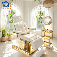 Lit de beauté électrique en cuir de luxe moderne avec base dorée, fonction massage, lumières intégrées pour salon de coiffure, hôtel, soins du visage et extensions de cils