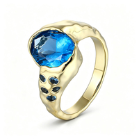 ZG Breiter Ring mit Hammerschlag-Optik, ovaler blauer Zirkonia im Lünettenfassung, Messing, vergoldet, Akzentstein-Schmuck
