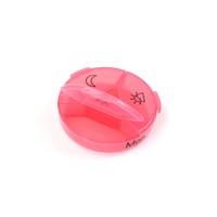Boîte à pilules ronde en plastique rose avec des icônes soleil et lune pour le rangement des médicaments