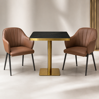 Ensemble table et fauteuils, surface en pierre frittée noire avec base en piédestal doré, mobilier pour café, terrasse et véranda