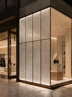 Façade en verre décorative encadrée de profilés en acier inoxydable sur mesure pour devanture de magasin de luxe