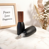Vente en gros de flacons à bille en verre noir mat opaque de 12 ml, flacons de luxe pour huiles parfumées avec bille en acier et couvercle en bois foncé naturel