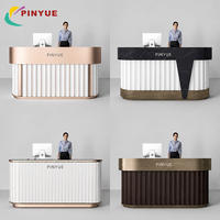 Bureau d'accueil de luxe en bois foncé avec façade à lattes verticales, profil incurvé, comptoir en laiton brossé et design contemporain pour hall d'accueil