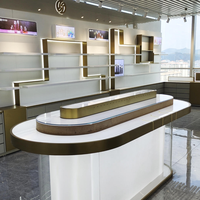 Comptoir d'exposition à 3 niveaux avec finition or brossé, vitrine blanche éclairée par LED avec verre incurvé et vue à 360° pour magasin de détail