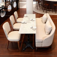 Ensemble de mobilier de restaurant, café et hôtel : canapé, table et chaises en velours blanc, avec banquette minimaliste carrée en pierre.