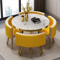 Ensemble de table à manger ronde de luxe en métal doré avec quatre chaises rembourrées, plateau de table aspect marbre et finition dorée stable