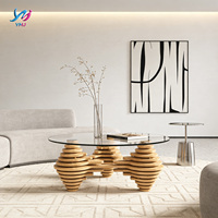 Table basse moderne et écologique au design unique avec plateau en verre transparent et pieds en bois empilés artistiquement pour salon, espace de réception à domicile