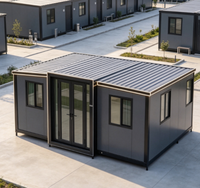 Bâtiment de dortoir modulaire gris en conteneurs, avec cadre noir, bande lumineuse LED, porte double vitrée, logement préfabriqué pour personnel en trois sections