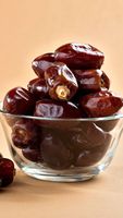 Verse bruine dadels, ovale vorm, gerimpelde textuur, met pit, natuurlijke gedroogde fruitsnack