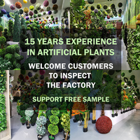 Panneau mural de haie artificielle 50x50cm en herbe verte avec feuilles de buis et fleurs rouges pour la décoration paysagère et commerciale