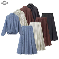 En stock, vente en gros : Ensemble jupe deux pièces à pois pour femme, comprenant une blouse à manches longues à col noué et une jupe longue à volants, idéal pour les voyages et les tenues de boutique.