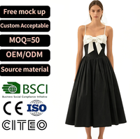 Robe midi élégante pour femme, noire et blanche contrastée, avec nœud, bretelles spaghetti, décolleté cœur et jupe plissée, pour soirée et fête