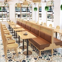 Banquette en bois de style Japandi avec dossier en rotin et chaises à coussin en cuir avec tables à piétement noir pour café