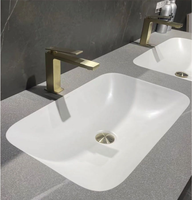 Meuble-lavabo mural en céramique intégré avec vasque en pierre frittée grise au design moderne, comptoir en pierre frittée pour usage hôtelier