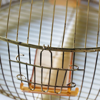 Fabrication de cages à oiseaux rondes en métal de couleur dorée dans des cages à oiseaux en vrac
