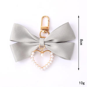 Bagages créatifs exquis de haute qualité accessoires de téléphone portable personnalisés porte-clés en gros de noeud de papillon d'amour de perle - Product Image 2