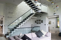 Escalier en zigzag noir avec marches en bois et balustrade en verre