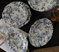Assiettes en porcelaine émaillée bleu et blanc de style français classique moderne, série de vaisselle écologique à pied avec dentelle en relief, vente en gros