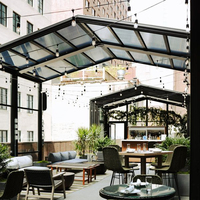Véranda motorisée rétractable en aluminium robuste à grande portée avec toit coulissant automatique en verre pour terrasse de restaurant