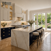 Meubles de cuisine bicolores BEIMEI : base bleu marine américain, unités murales crème alabastro, îlot Calacatta cascade, armoires de villa
