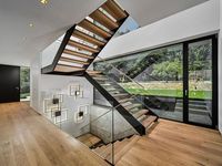Maßgefertigte gerade Doppelträger-Treppe mit schwarzen Stahlträgern, Holzstufen und rahmenlosem Glasgeländer für Zuhause