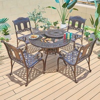 ronde de foyer de barbecue coulé dans le jardin d'un hôtel mobilier d'extérieur ensemble table à manger et chaises en aluminium