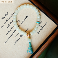 Bracelet en perles de pierres précieuses blanches avec accents turquoise et pompon décoratif